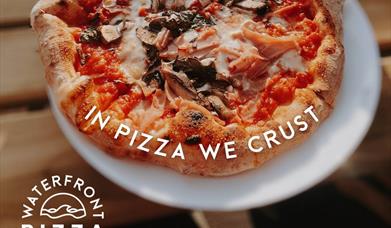 A pizza with the text 'in pizza we crust'.