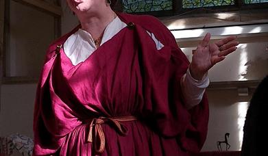 A lady dressed in a red period costume.