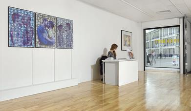 Art Exchange Gallery with lady at a desk and artwork on the walls