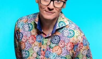 Image shows Ed Byrne looking at the camera with raised eyebrows