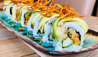 Sushi dish with avocado and crispy onions
