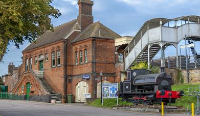 Outside of the East Anglian Railway Museum with a model steam train