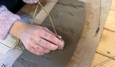 Lady imprinting lavender onto air dry clay