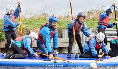 Youth group with paddles on the river