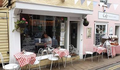Exterior of Timbers restaurant, with quaint white tables outside.